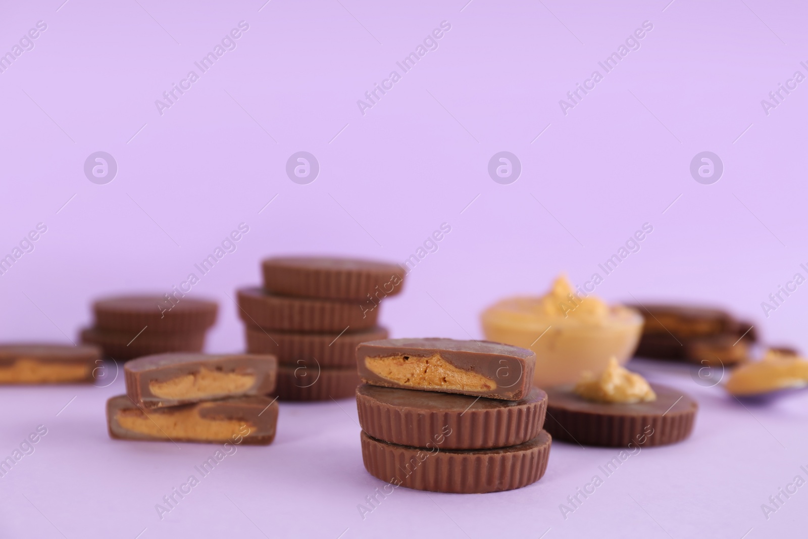 Photo of Sweet peanut butter cups on violet background