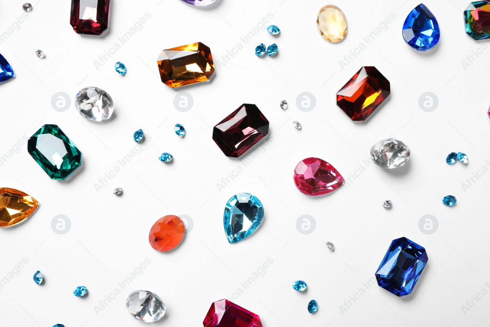 Photo of Different beautiful gemstones on white background, top view