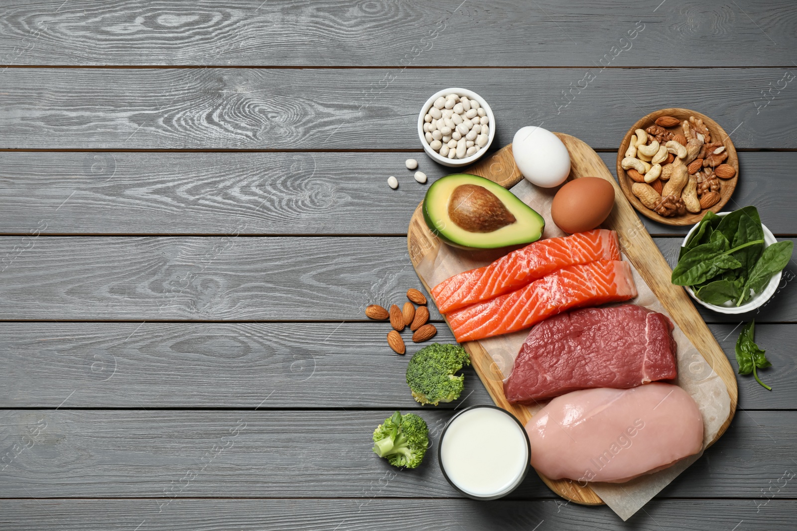 Photo of Products rich in protein on grey wooden table, flat lay. Space for text