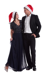 Beautiful happy couple in Christmas hats on white background