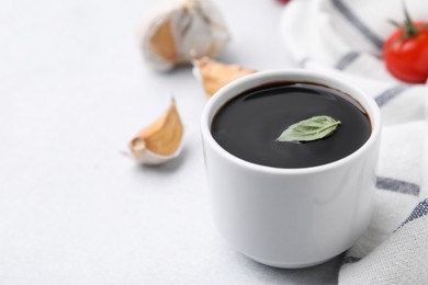 Photo of Organic balsamic vinegar and cooking ingredients on white table, closeup. Space for text