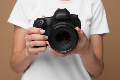 Photo of Photographer with camera on brown background, closeup