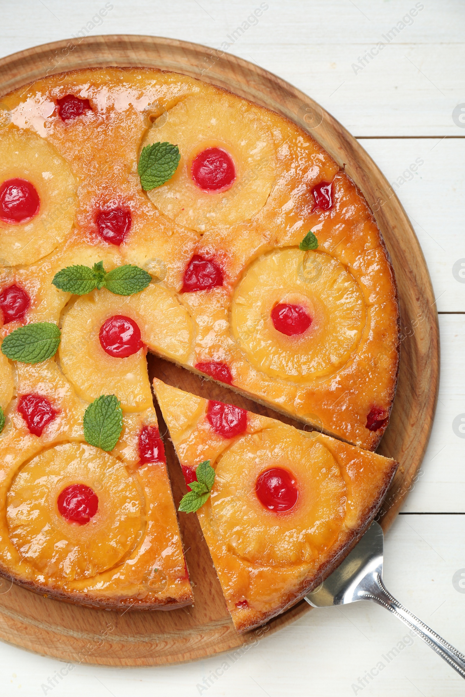 Photo of Delicious cut pineapple pie with cherry and mint on white wooden table, top view