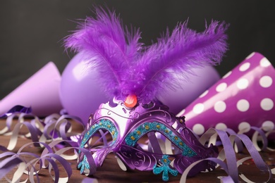 Beautiful purple carnival mask and  decor on wooden table, closeup
