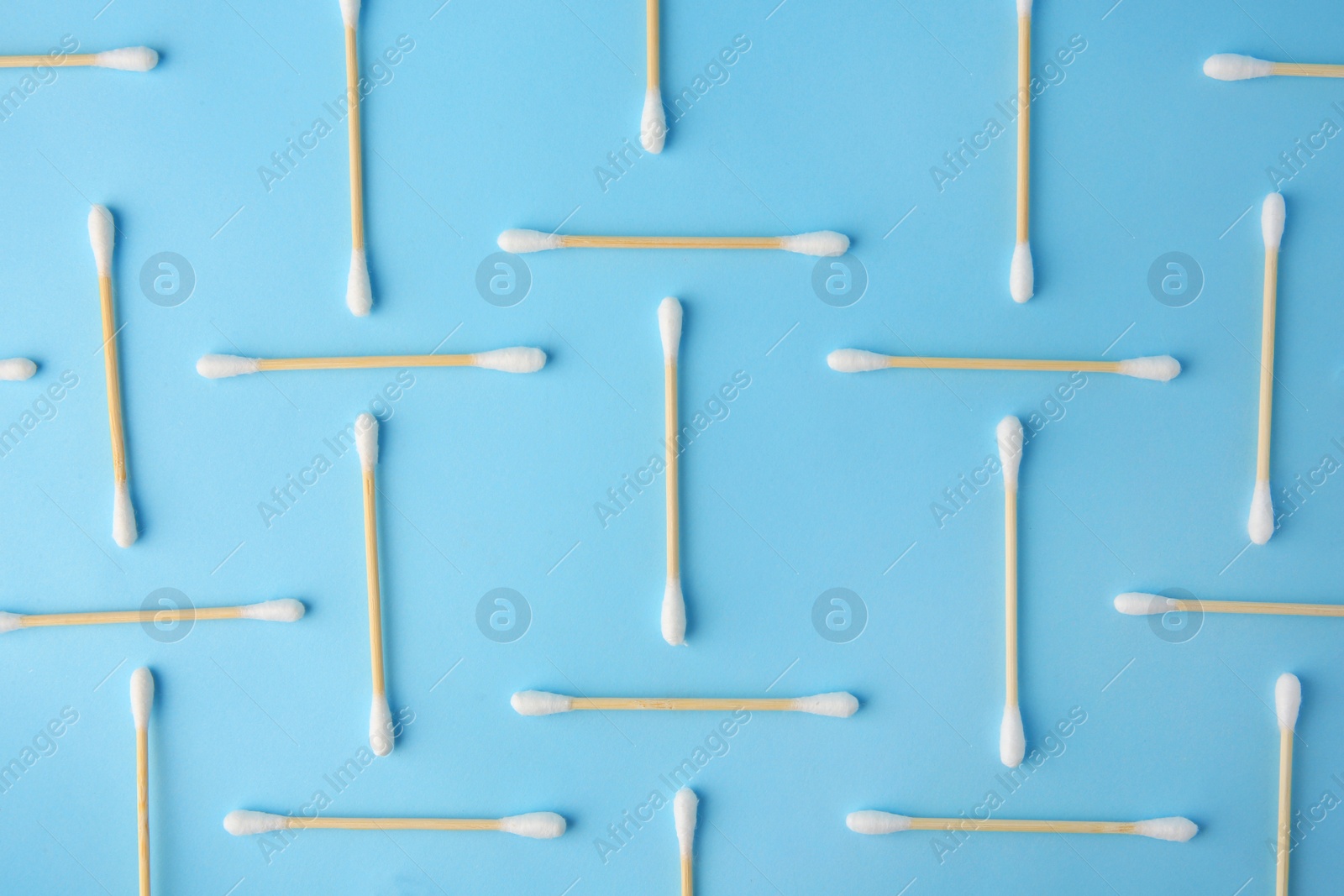 Photo of Many clean cotton buds on light blue background, flat lay