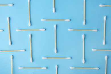 Photo of Many clean cotton buds on light blue background, flat lay