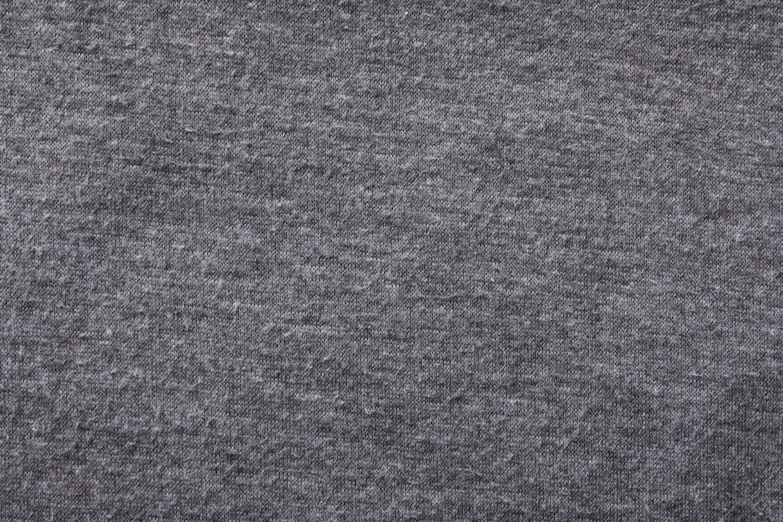 Photo of Grey cloth with lint as background, closeup. Before using of fabric shaver