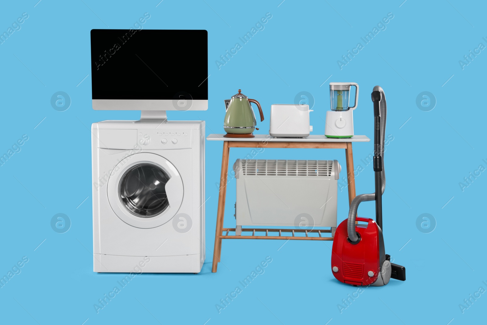 Photo of Set of different home appliances with vacuum cleaner on light blue background