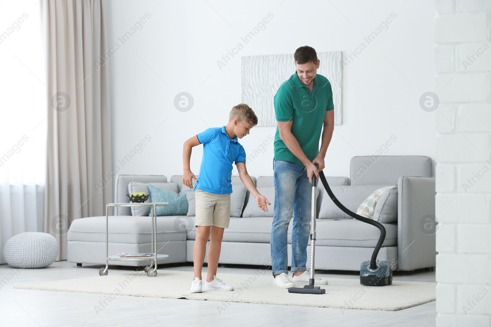 Photo of Dad and son cleaning living room together