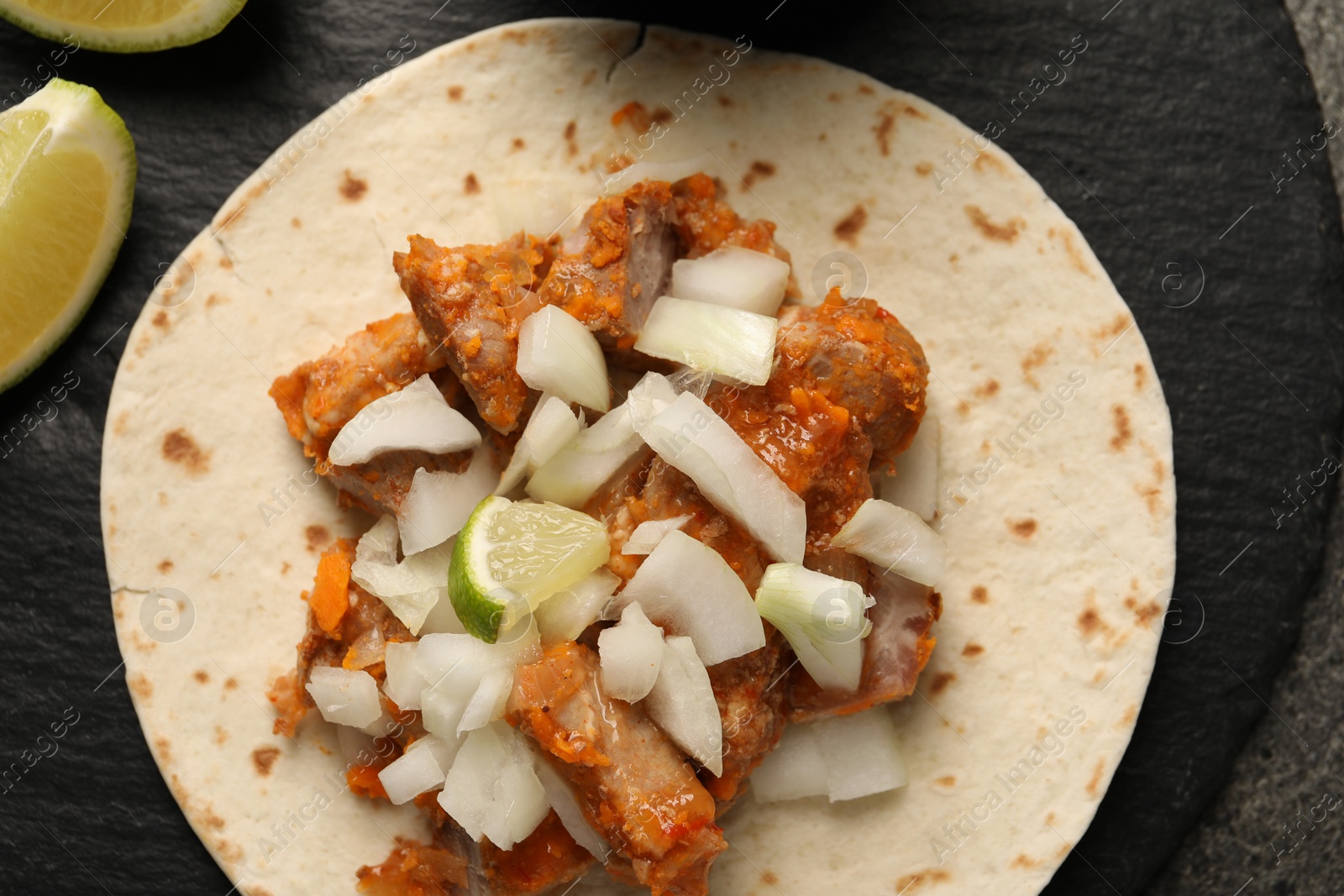 Photo of Delicious taco with vegetables, meat and lime on table, top view