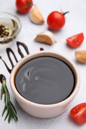 Photo of Organic balsamic vinegar and cooking ingredients on white table