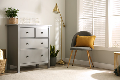 Photo of Grey chest of drawers in stylish room interior