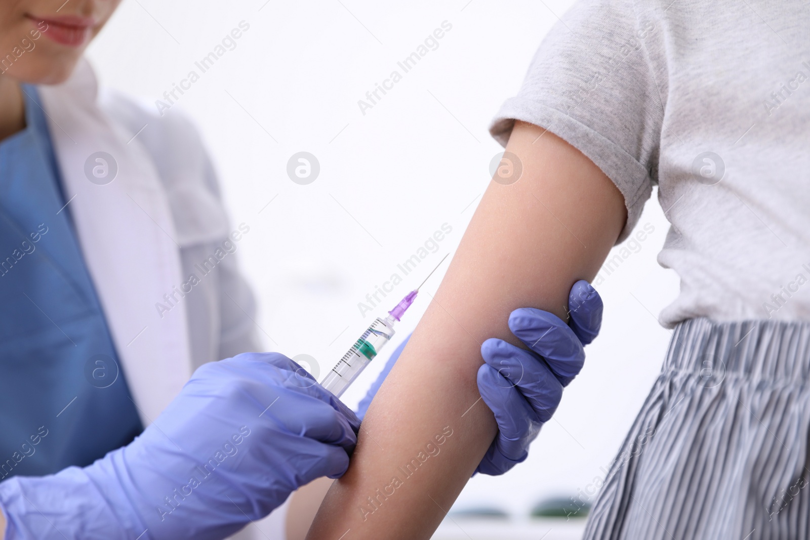 Photo of Little girl receiving chickenpox vaccination in clinic, closeup. Varicella virus prevention