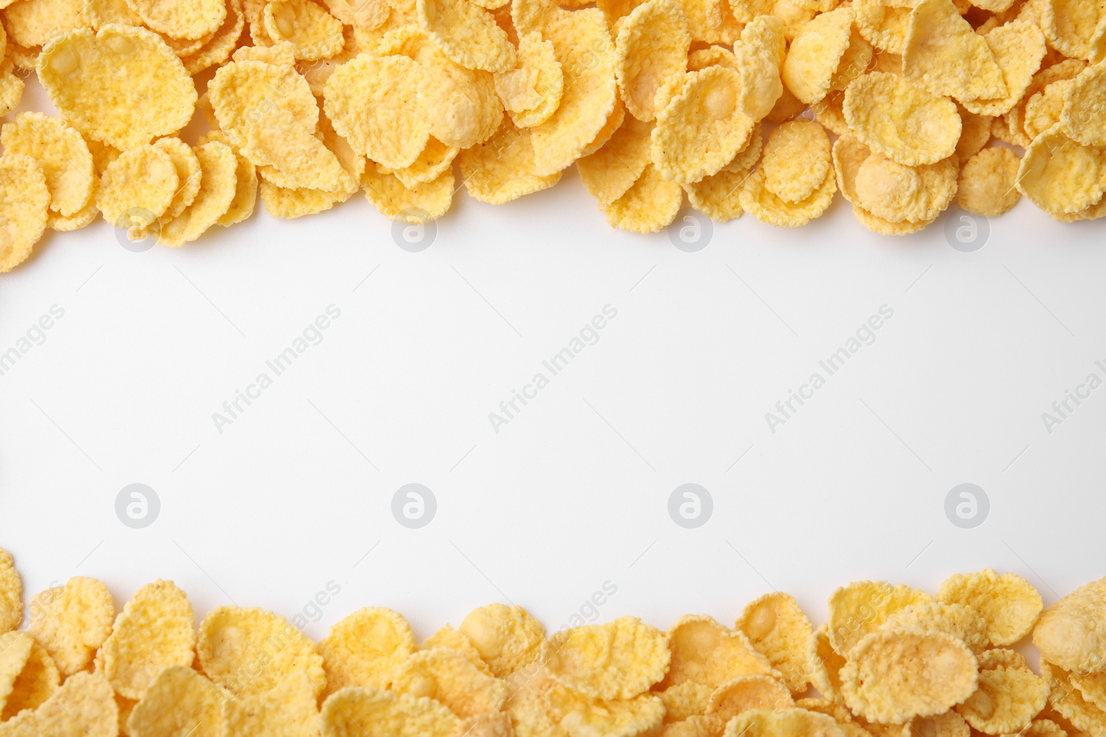 Photo of Breakfast cereal. Tasty corn flakes on white background, flat lay. Space for text