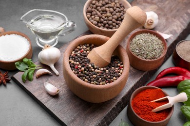 Photo of Mortar with different spices on grey table, closeup