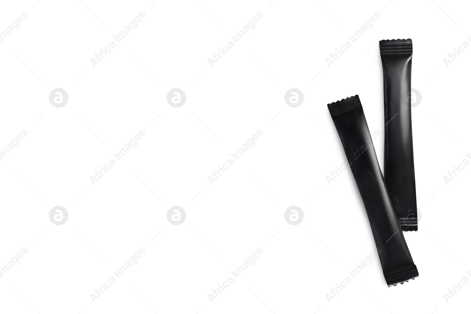 Photo of Black sticks of sugar on white background, top view