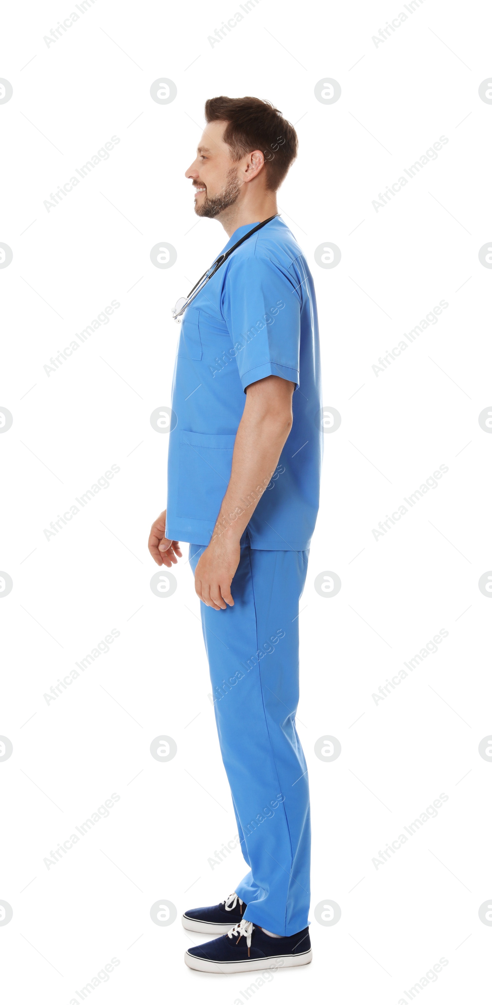 Photo of Full length portrait of smiling male doctor in scrubs isolated on white. Medical staff