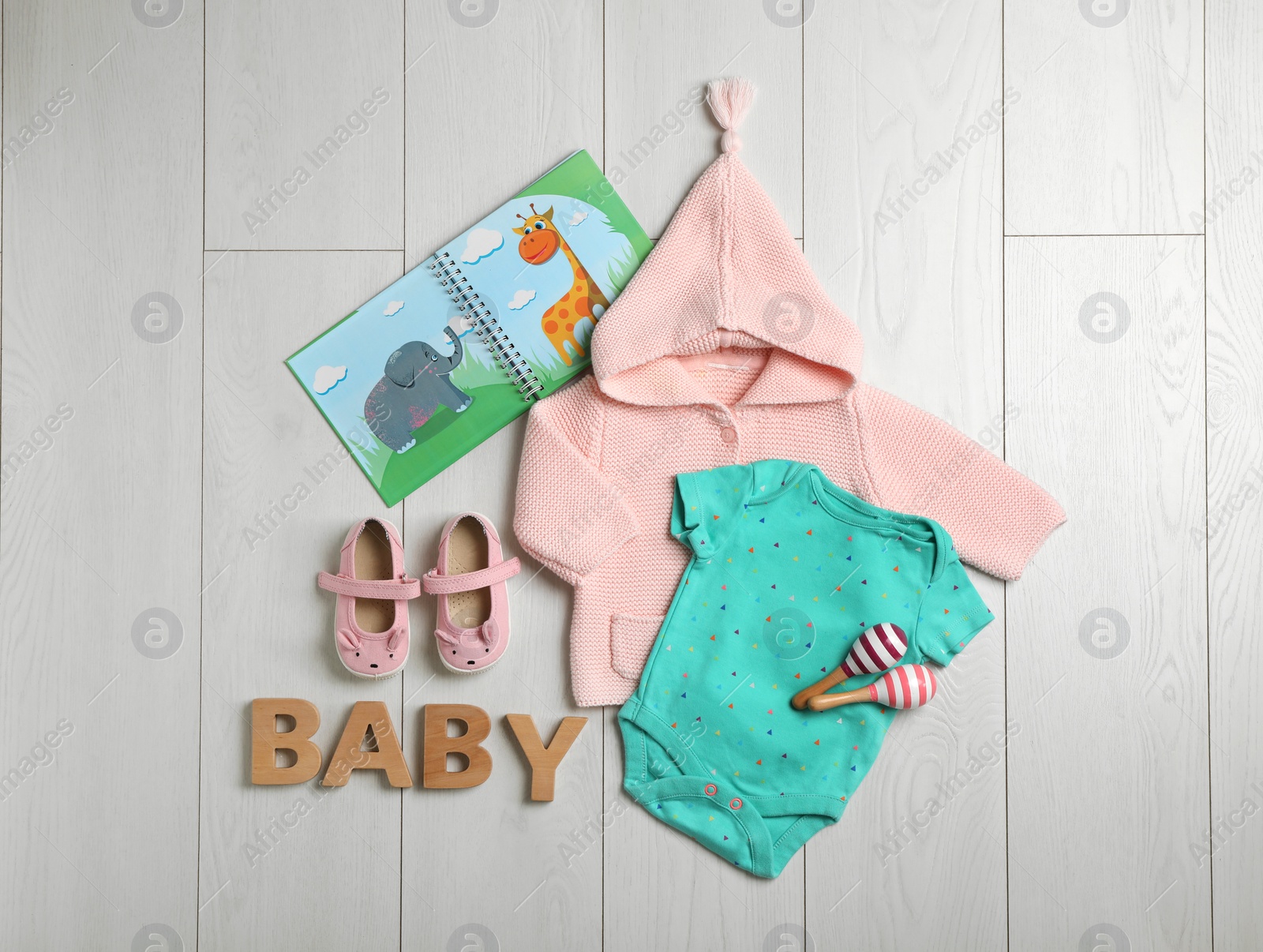 Photo of Flat lay composition with cute clothes on wooden background. Baby accessories