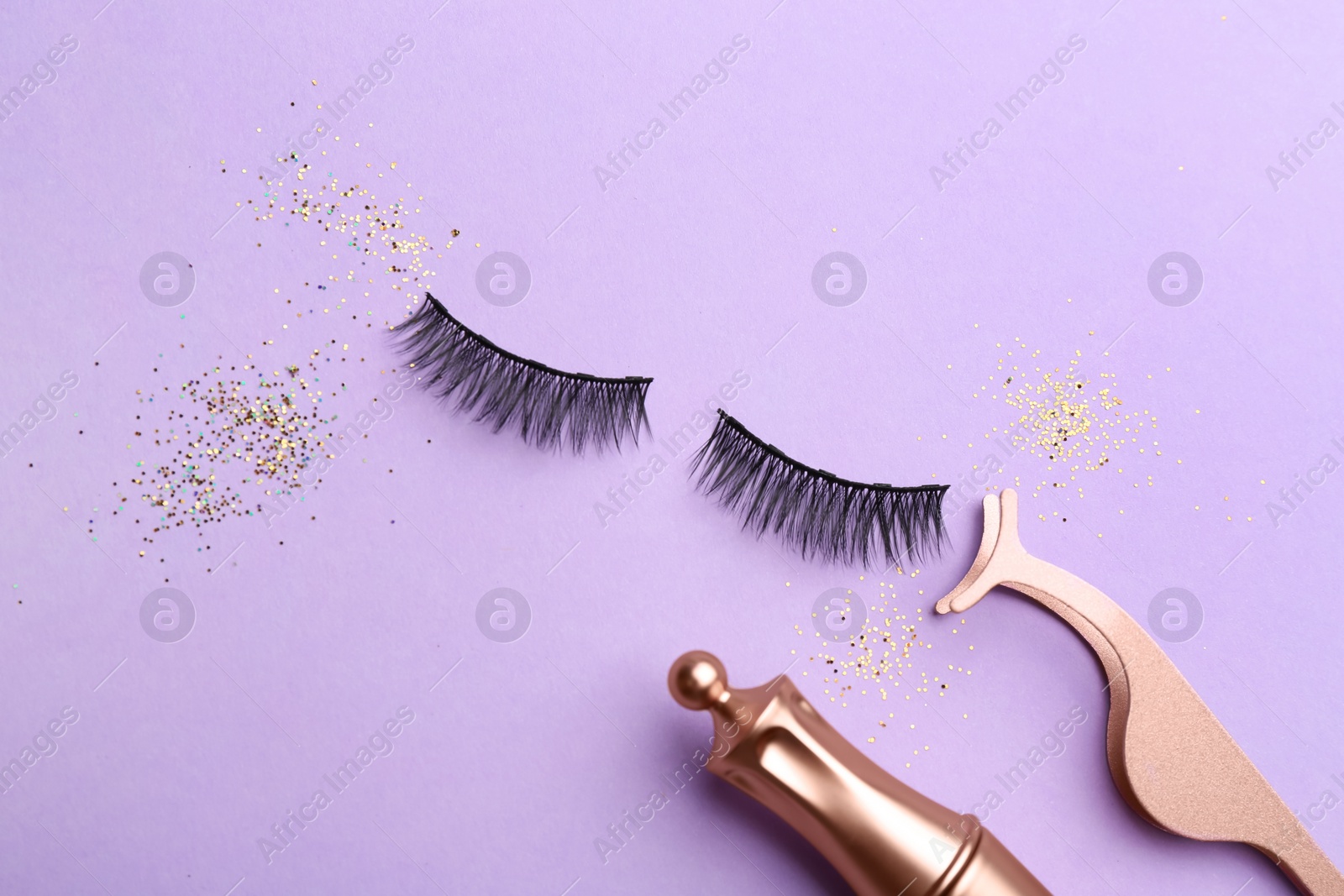 Photo of Flat lay composition with magnetic eyelashes and accessories on violet background
