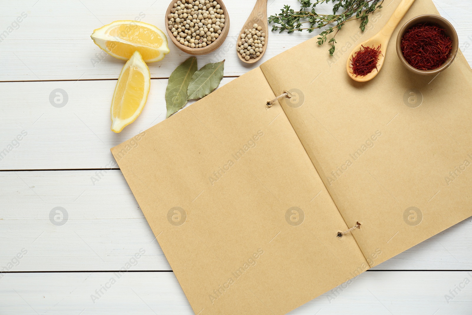 Photo of Blank recipe book and different ingredients on white wooden table, flat lay. Space for text