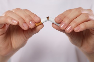 Photo of Stop smoking concept. Woman breaking cigarette, closeup