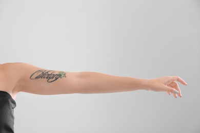 Photo of Female arm with tattoo on color background