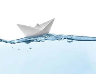 Image of Handmade paper boat floating on clear water against white background 