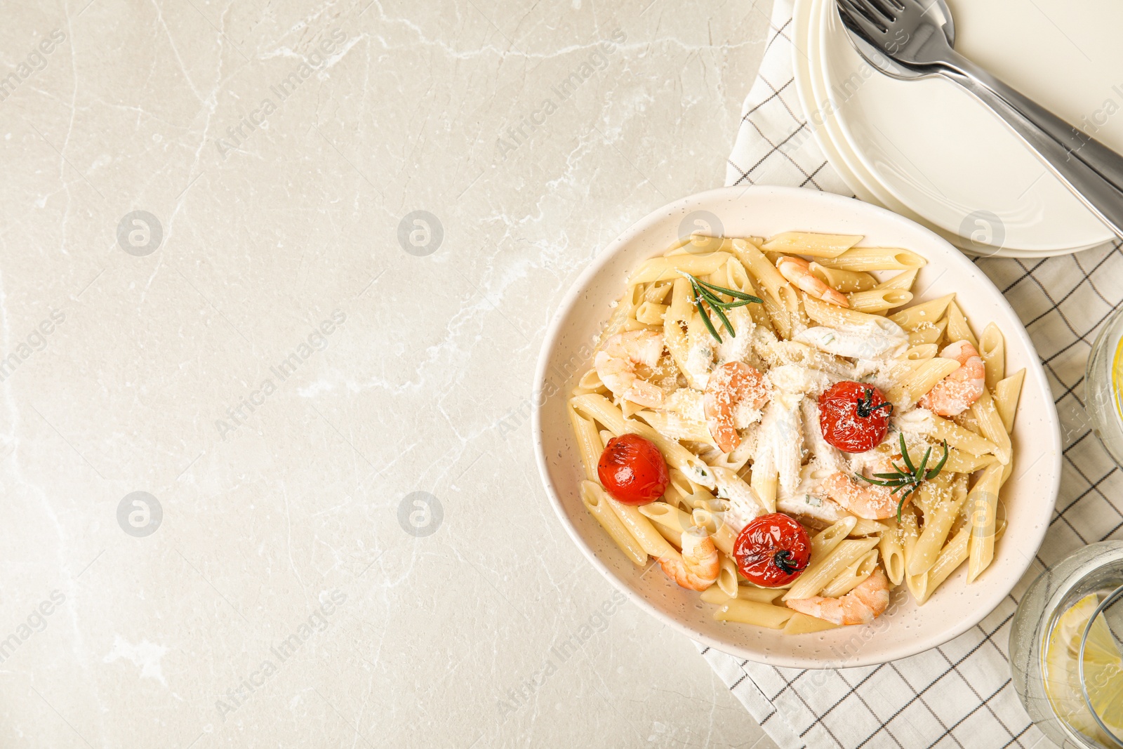 Photo of Delicious pasta with shrimps on marble table, flat lay. Space for text