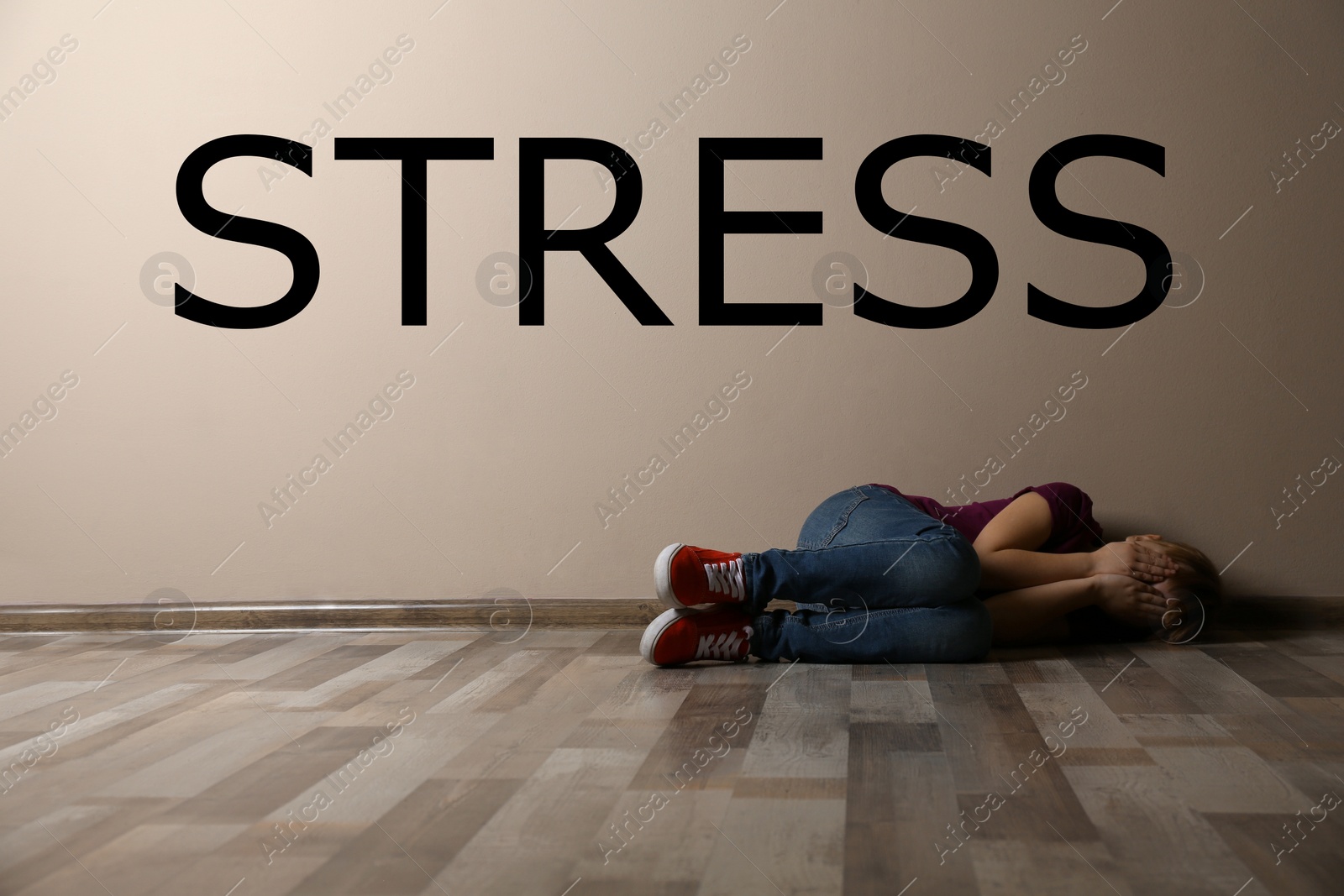Image of Word STRESS and depressed young woman lying on floor indoors 