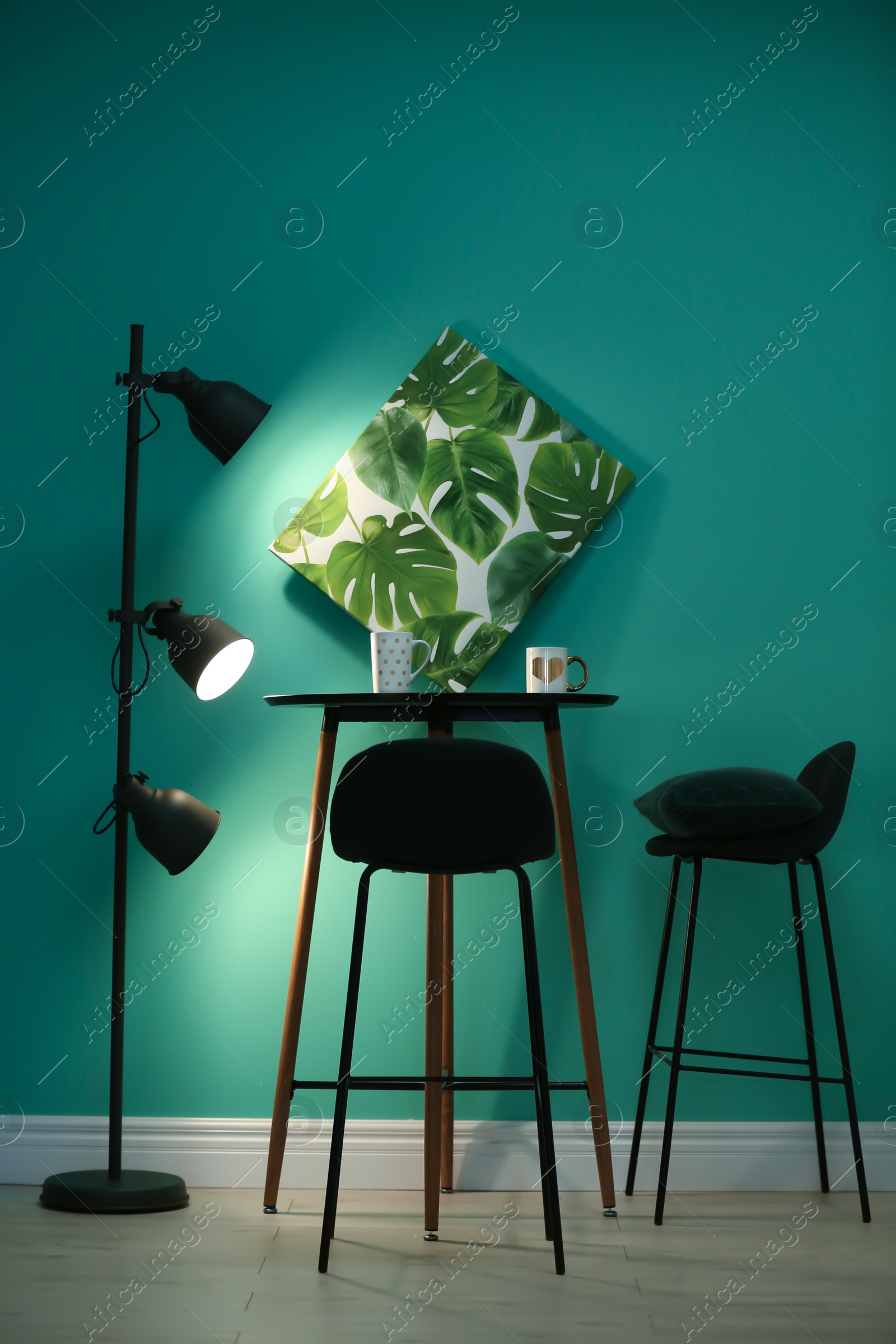 Photo of Modern floor lamp with stylish furniture near color wall