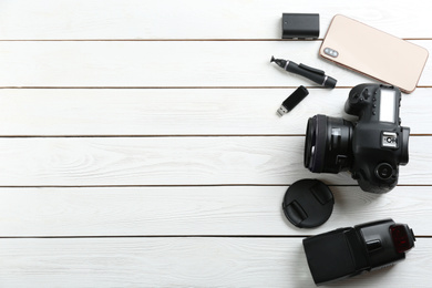 Photo of Flat lay composition with equipment for professional photographer on white wooden table. Space for text