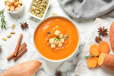 Photo of Flat lay composition with bowl of sweet potato soup on table