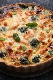 Photo of Delicious homemade quiche with salmon and broccoli on table