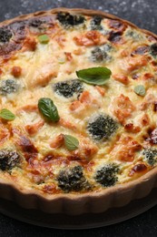 Delicious homemade quiche with salmon and broccoli on table