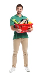 Photo of Young man with shopping basket full of products isolated on white