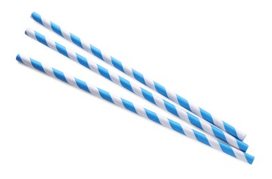 Photo of Striped paper cocktail straws on white background, top view
