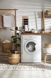 Photo of Stylish bathroom interior with modern washing machine