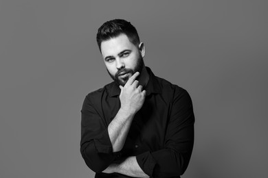 Photo of Portrait of handsome bearded man on grey background. Black and white effect