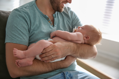 Photo of Father with his newborn son at home, closeup