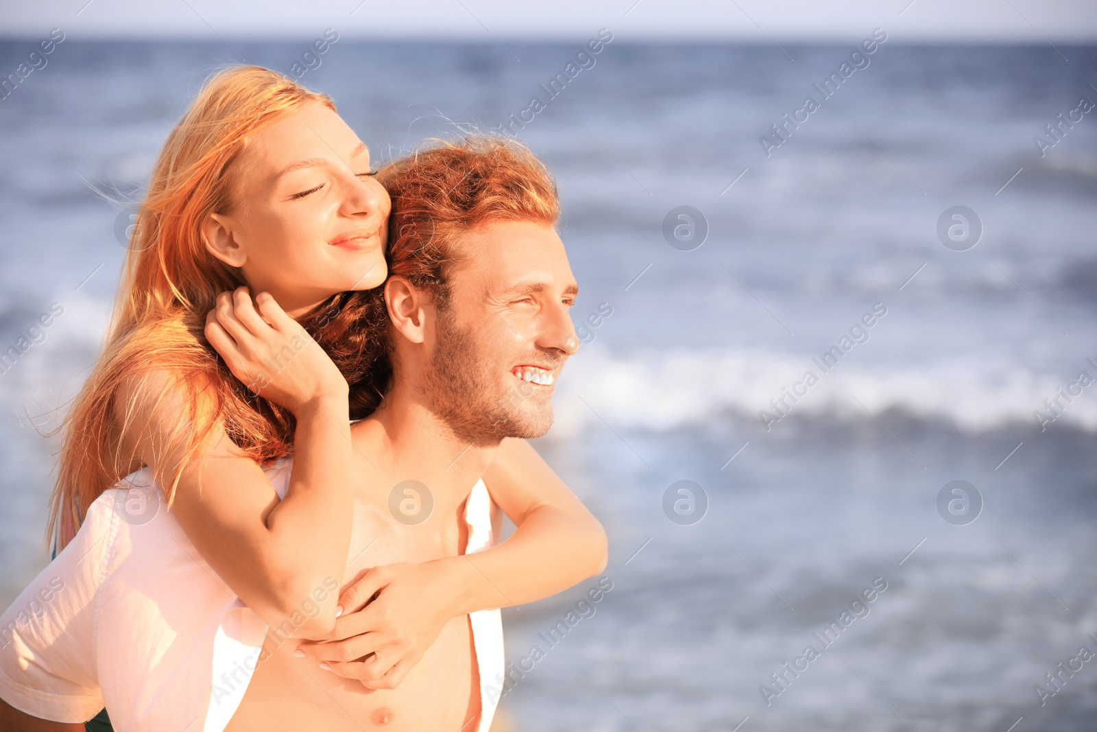 Photo of Young lovely couple on beach at sunset