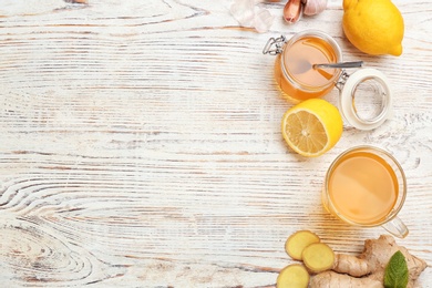 Photo of Cup with hot tea and other cold remedies on wooden table, top view