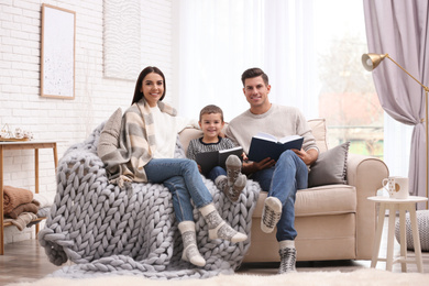 Photo of Happy family with little son reading books at home. Winter vacation