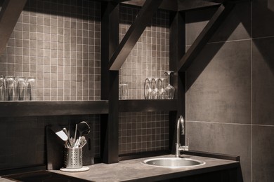 Stylish metal sink and utensils in hotel kitchen. Interior design