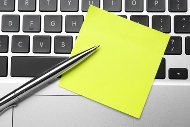 Photo of Empty sticky note and pen on laptop, top view. Space for design