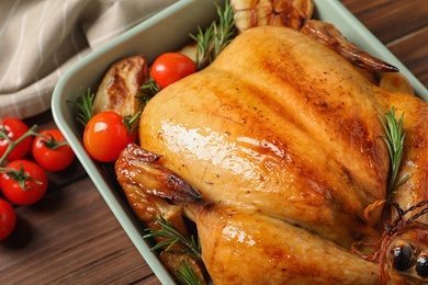 Photo of Cooked turkey with vegetables and rosemary in dish on table, closeup