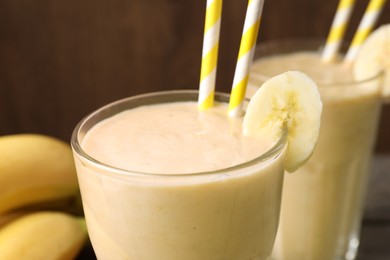 Photo of Glass with banana smoothie on table, closeup