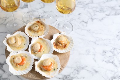 Photo of Fried scallops in shells and wine on white marble table, above view. Space for text