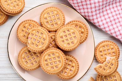 Photo of Tasty sandwich cookies with cream on white wooden table, flat lay