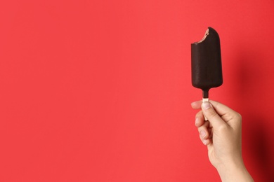 Photo of Woman holding delicious ice cream with chocolate against color background, space for text