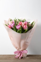 Photo of Bouquet of beautiful tulips on wooden table